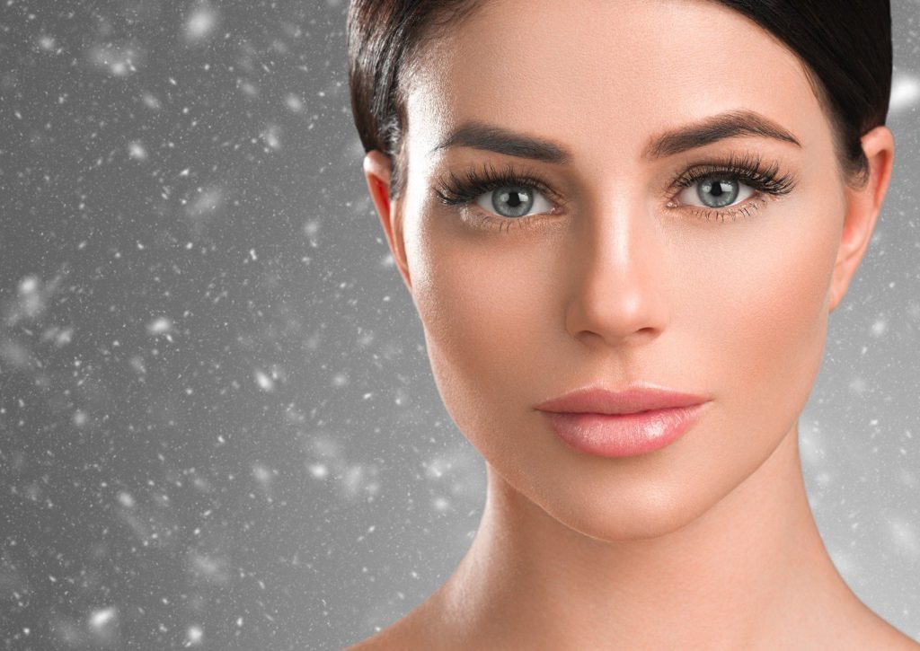Girl with beautiful lash extensions standing in the snow